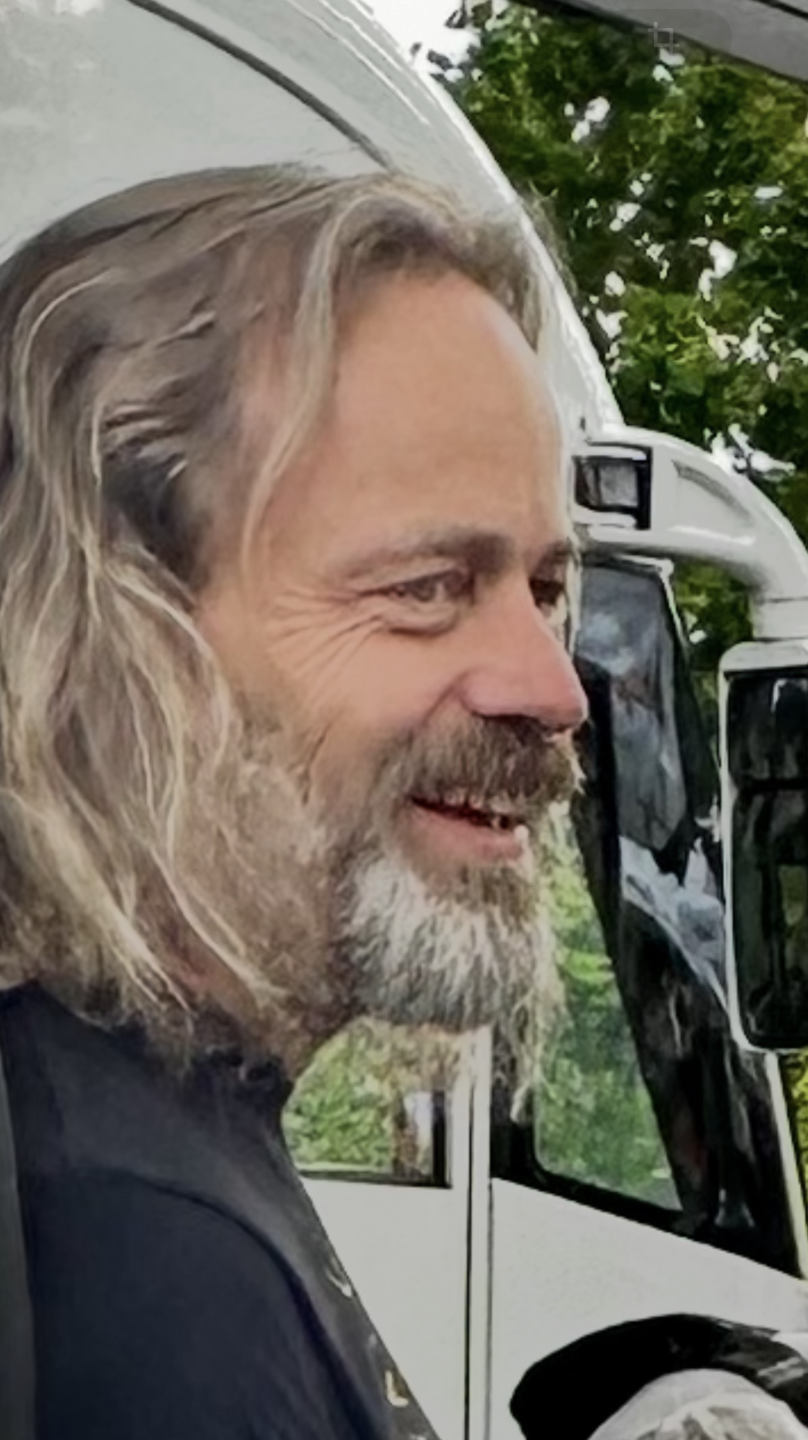 Joachim Heuer, mit langen Haaren und Bart, lächelt im Profil. Er wirkt authentisch, nahbar und voller Energie