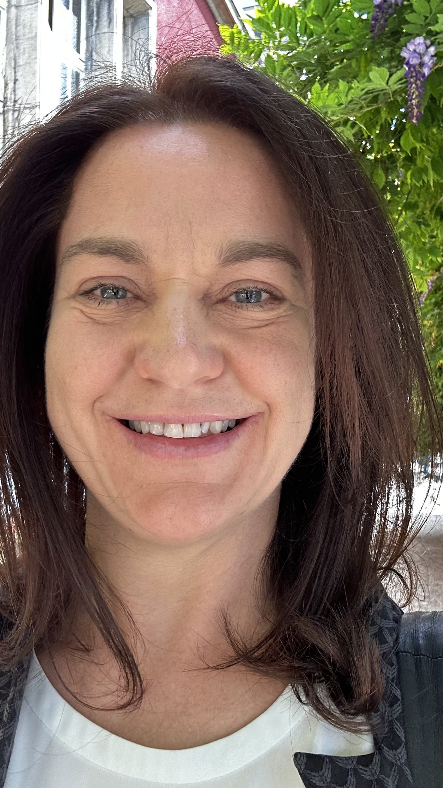 Portrait Dorothee Conrad im Business-Anzug  mit Hintergrund im Grünen